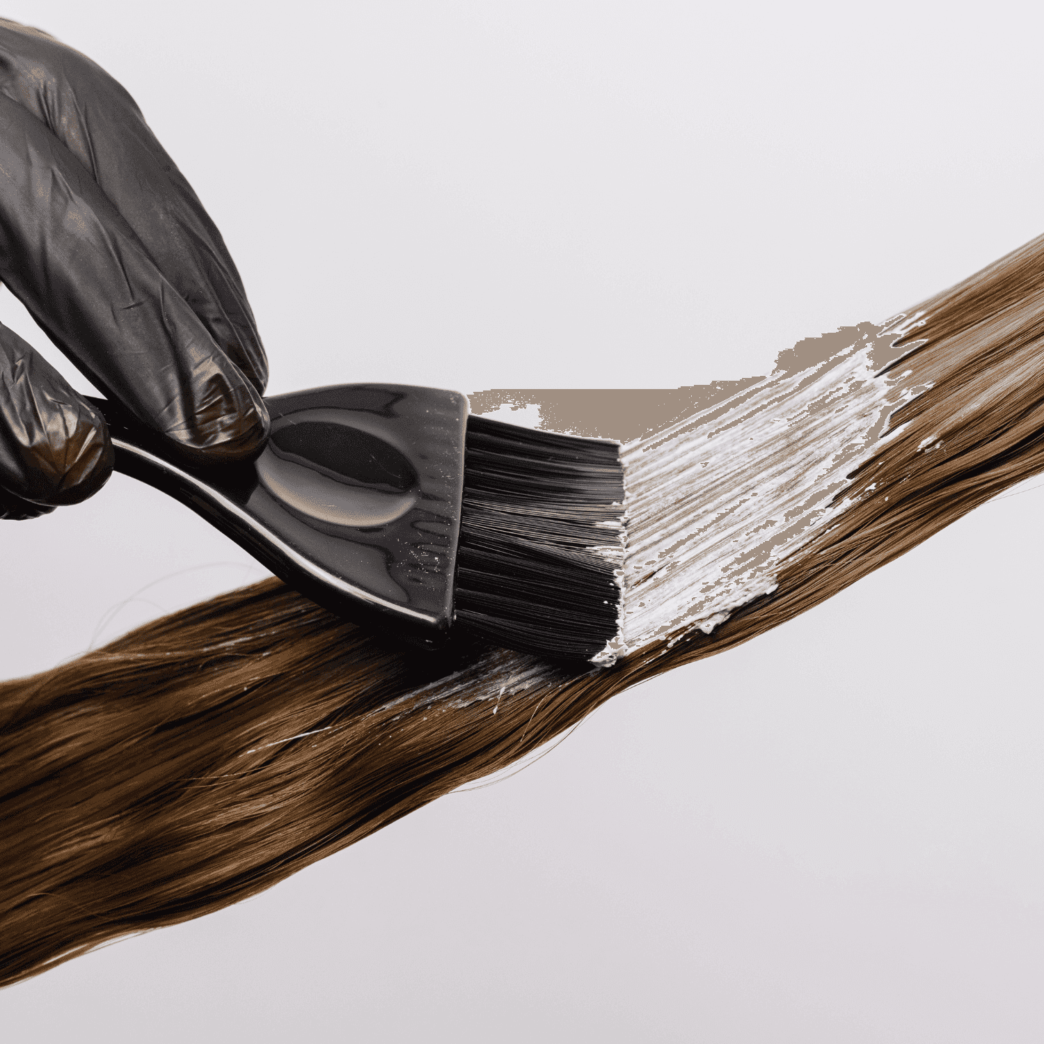 Hair being dyed brown with a brush.